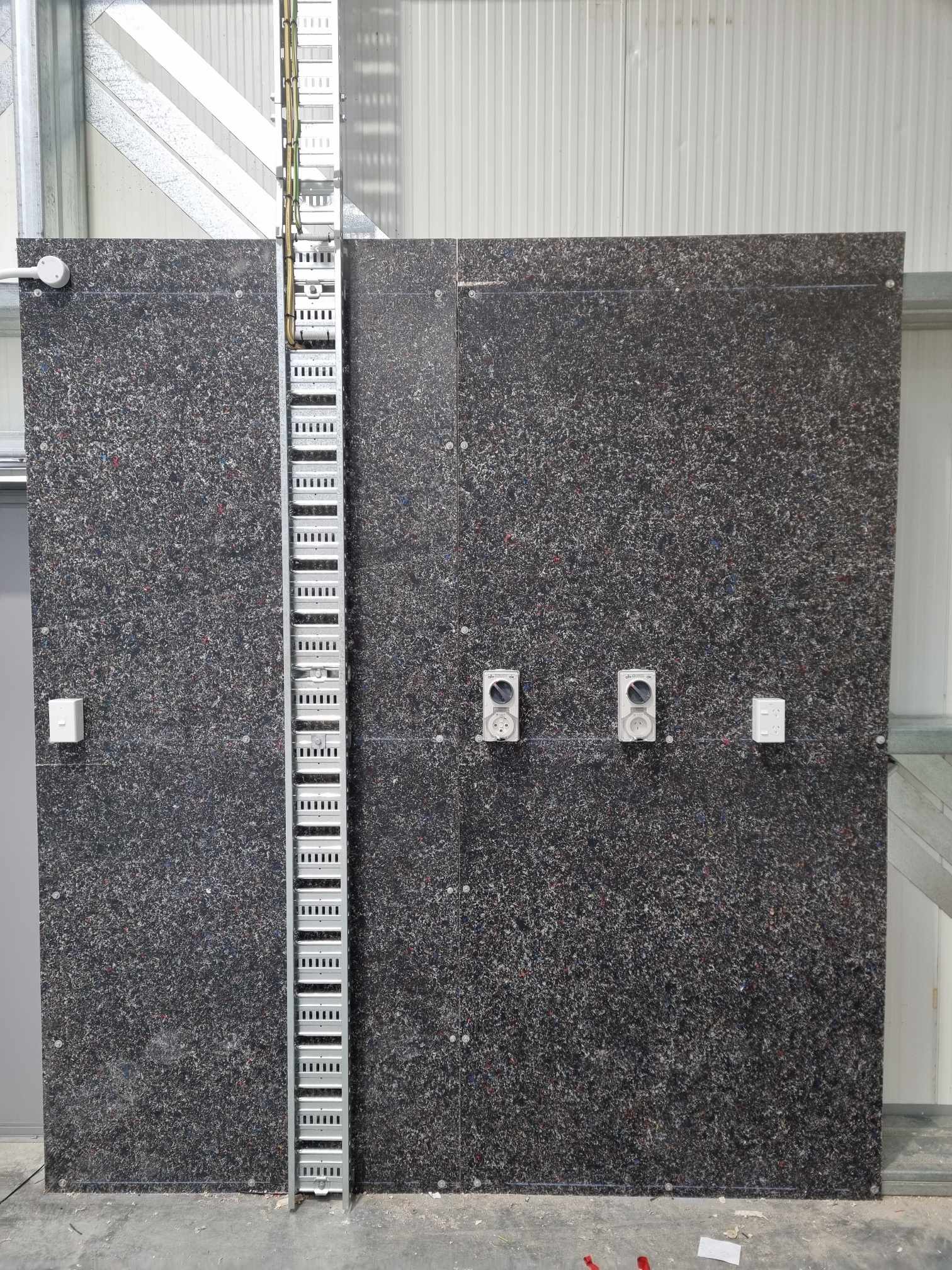 Industrial power outlets and cable ladder on a workshop wall