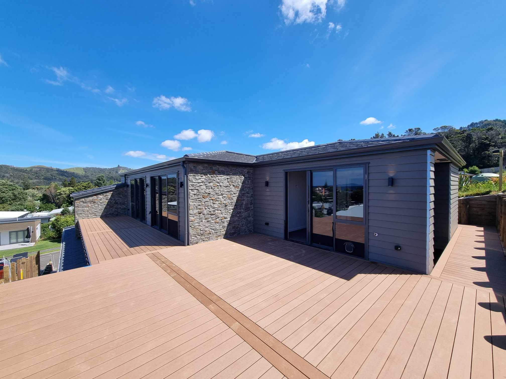 New build exterior with outdoor wall lights and rooftop deck