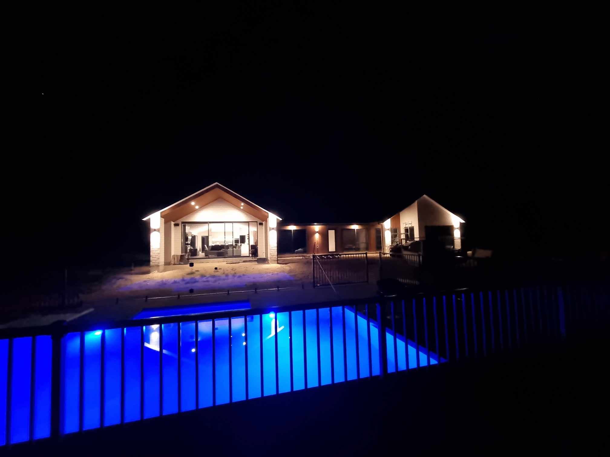 House exterior lighting with illuminated swimming pool at night