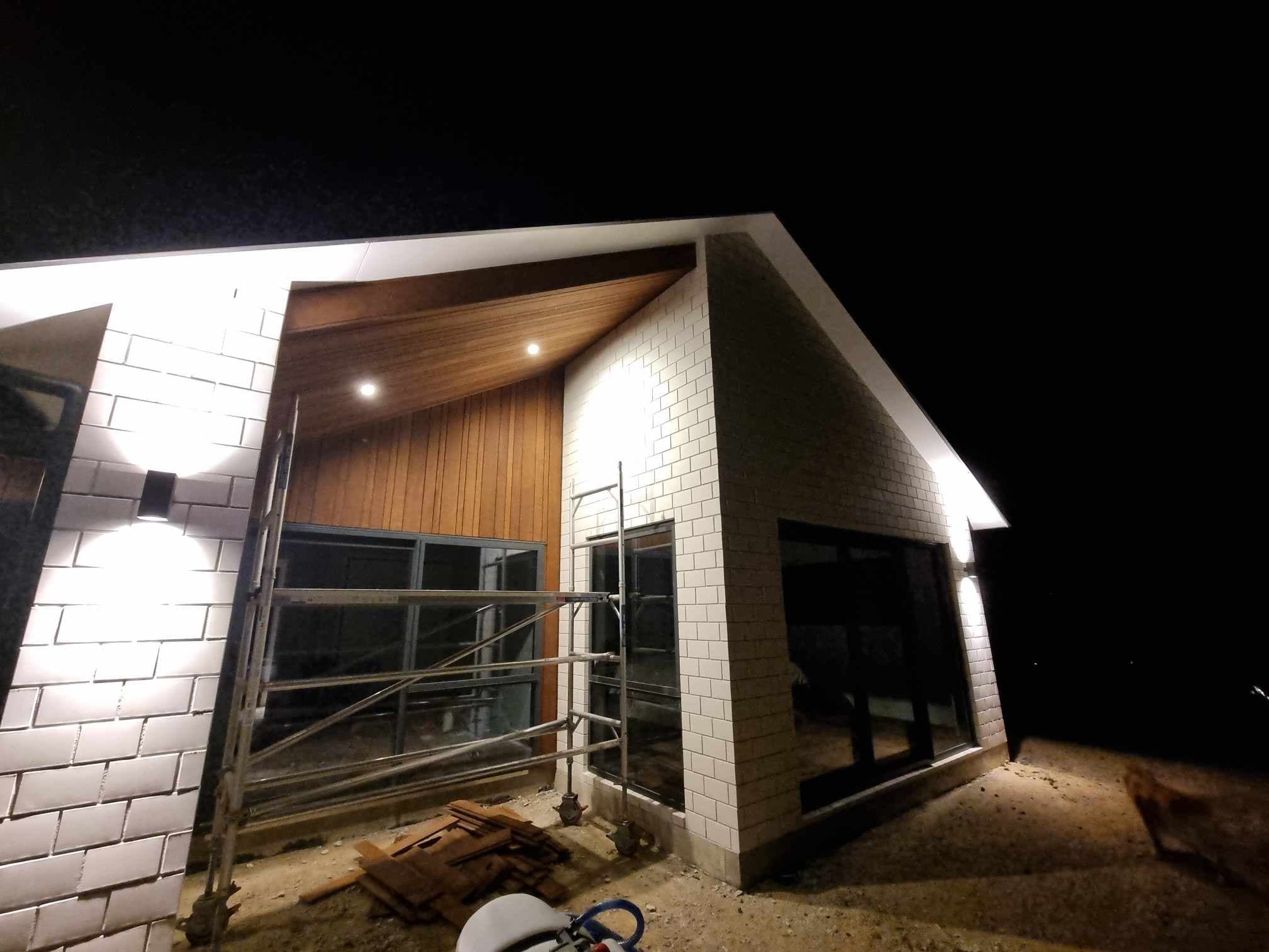 Exterior soffit downlights and wall lights on a new build at night